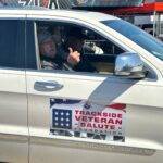 NOMINATEd VETERAN giving a thumbs up riding in a Trackside Veteran Salute pit car